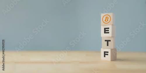 Exchange Traded Fund (ETF) and bitcoin cryptocurrency concept. Entering the digital money fund concept. Vertical wooden cube with bitcoin icon standing with "ETF" text. Grey background, copy space.