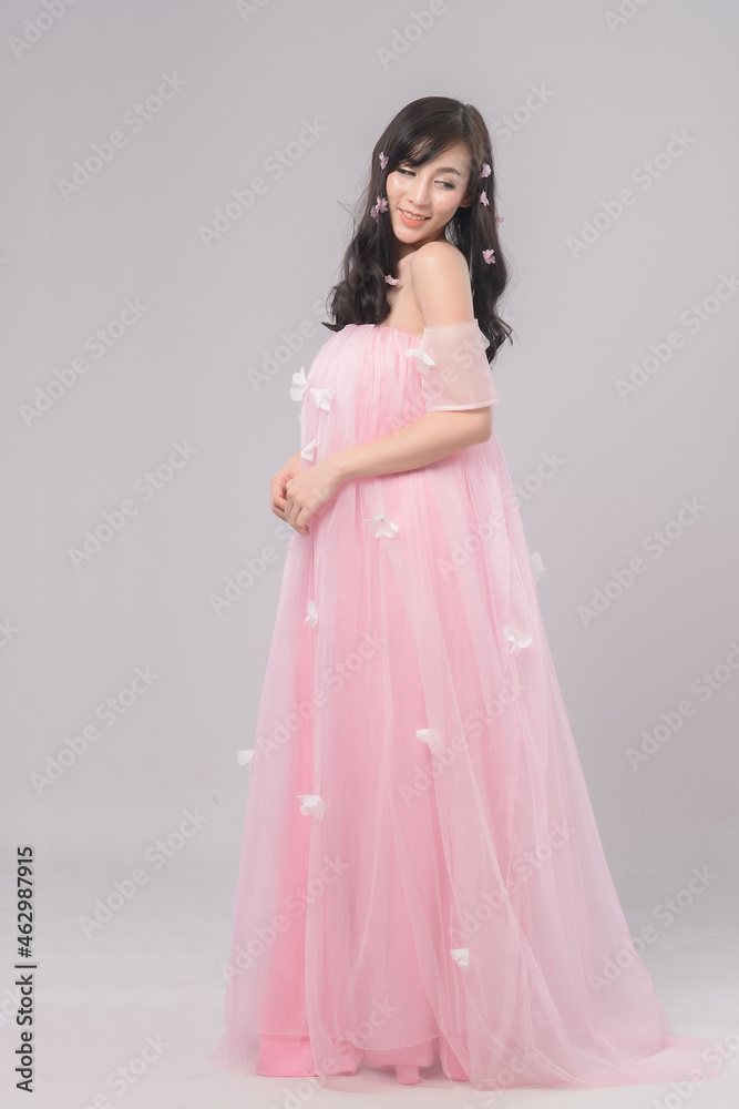 Portrait of beautiful asian woman bride in pink dress. Thai model posing in studio just married wedding concept.
