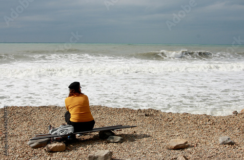lonely woman sitting by the sea during a storm 