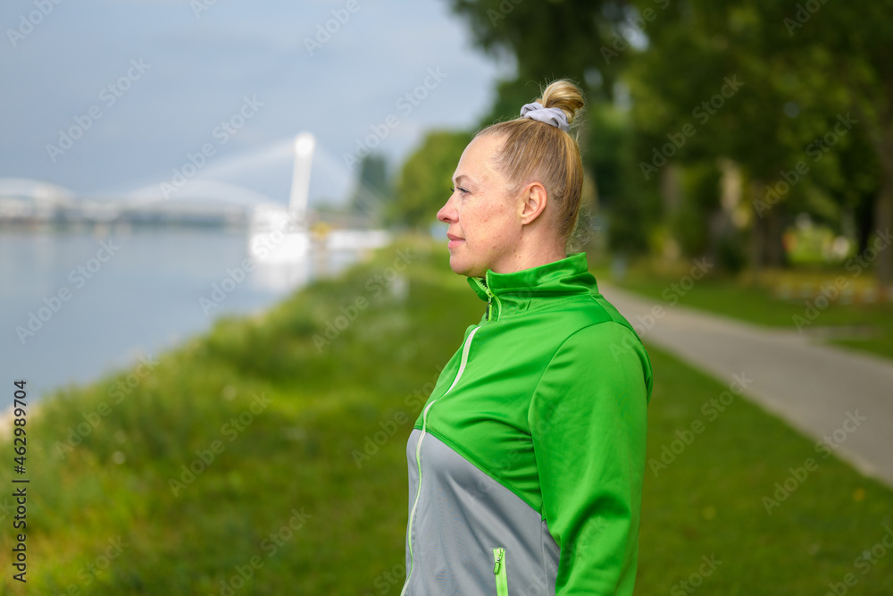 Fit healthy woman enjoying a jog along a river bank Fit healthy woman enjoying a jog along a river bank