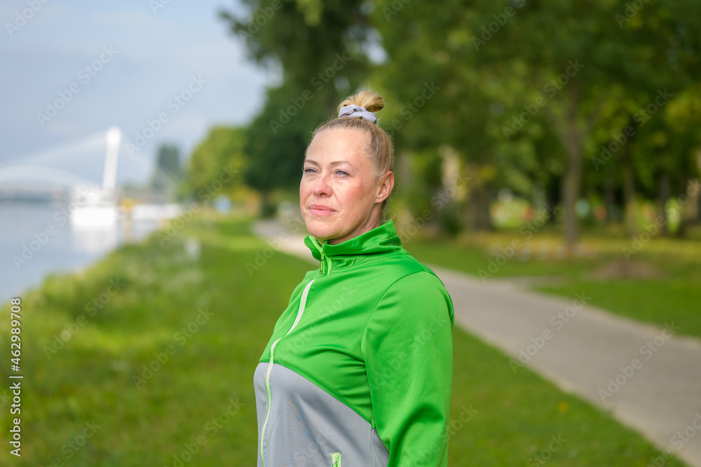 Fit healthy woman enjoying a jog along a river bank Fit healthy woman enjoying a jog along a river bank
