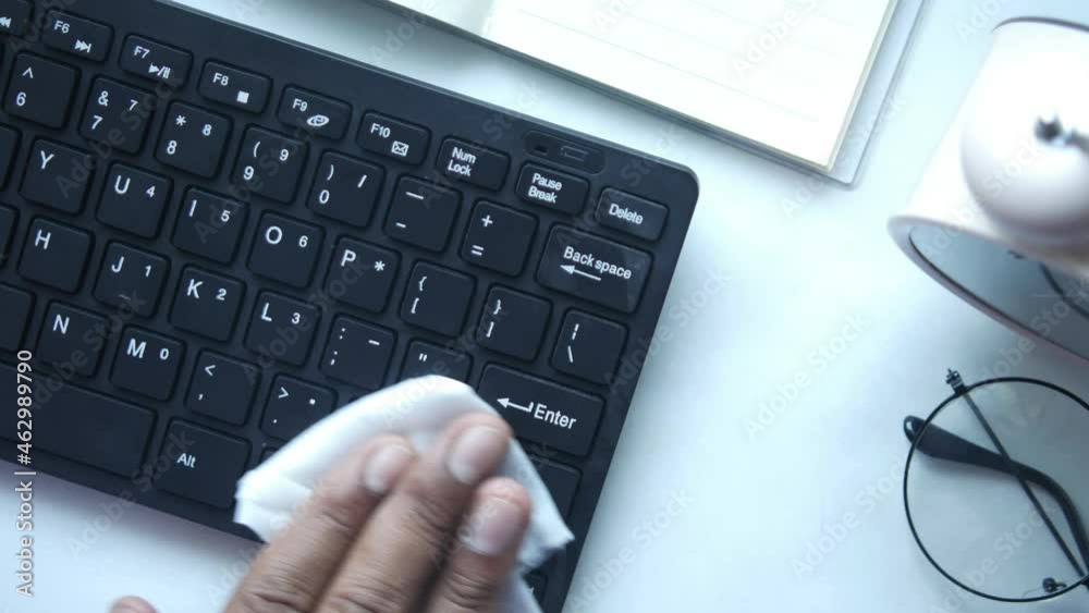 disinfecting keyboard with white tissue on table disinfecting keyboard with white tissue on table