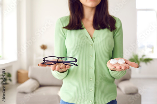 Konstfotografi Woman making choice between glasses and eye lenses