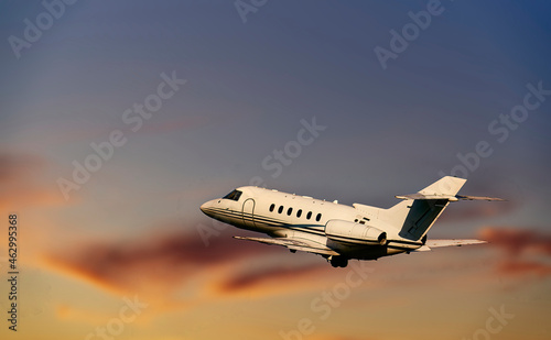 Fotografia, Obraz Private airplane jetliner flying above clouds in beautiful sunset light