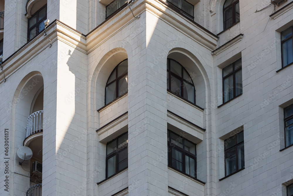 The faсade is a classic white stone building with rounded windows and a wrought-iron balcony. Soviet architecture