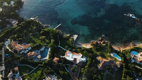 villas and hotels in paradise on the island of sardinia italy. right on the bay and with a charming white beach. perfect for swimming, diving. warm light shines, clear water. drone aerial view.
