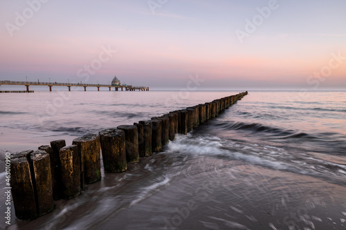 sunrise at the coast of baltic sea with pier and icoming waves at the groins  Zingst   Western-Pomerania  Germany 