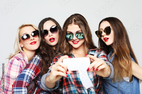 four happy teenage girls with smartphone taking selfie