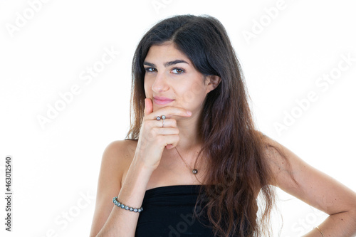 young pensive brunette woman smiling on white background hand on chin