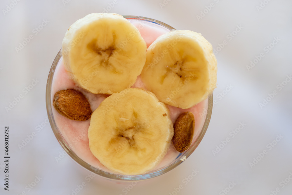 top view of a dairy dessert with banana, almond in a glass. top view of a dairy dessert with banana, almond in a glass.