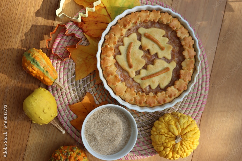 Traditional homemade Apple Pie with fall decoration on a wooden table with ornamental pumpkins and fallen leaves Traditional homemade Apple Pie with fall decoration on a wooden table with ornamental pumpkins and fallen leaves
