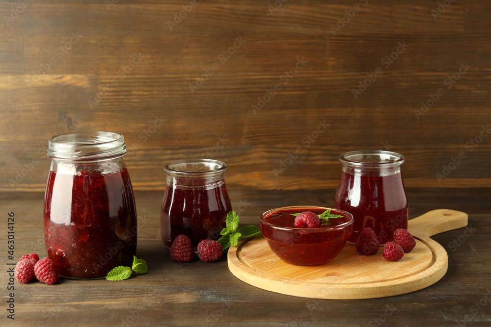 Concept of tasty food with raspberry jam on wooden background Concept of tasty food with raspberry jam on wooden background