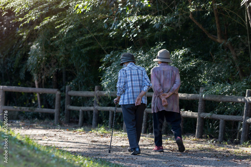 秋の公園で散歩しているシニア女性の姿