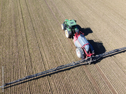 Aerial view tractor fertilizes a field