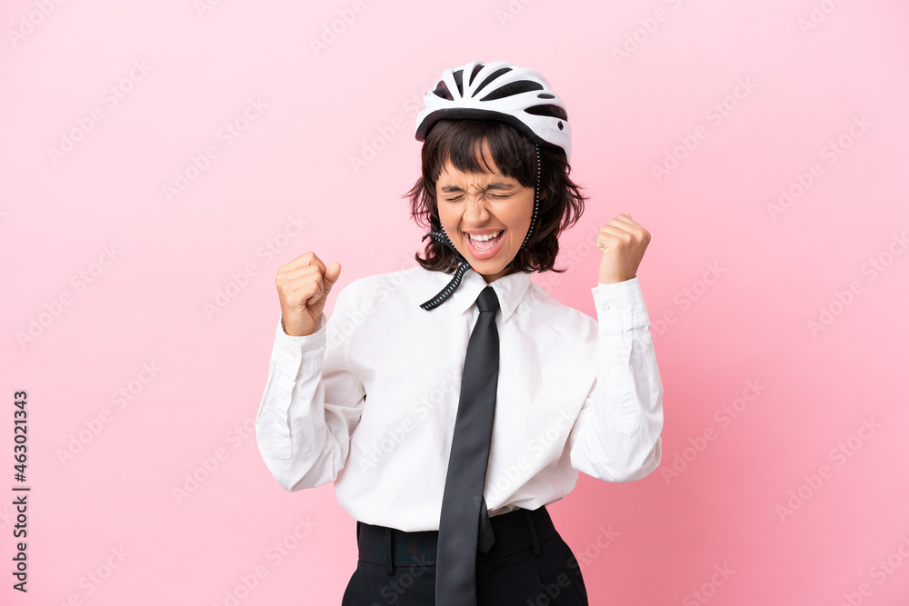 Young girl person with a bike helmet isolated on pink background celebrating a victory Young girl person with a bike helmet isolated on pink background celebrating a victory