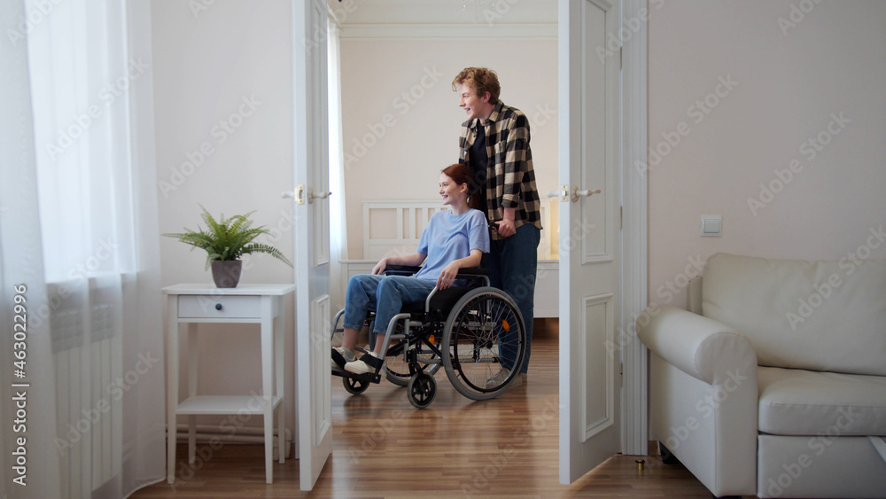 A man is driving his girlfriend in a wheelchair A man is driving his girlfriend in a wheelchair