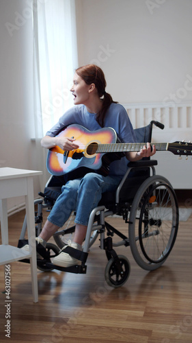 A disabled lady is playing the guitar and singing songs