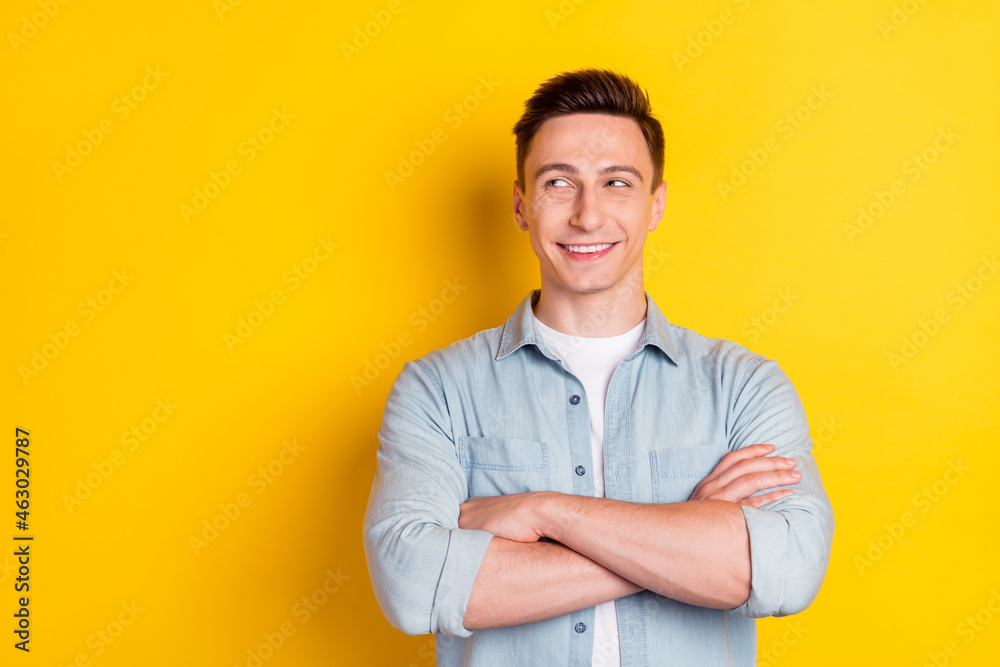 Portrait of attractive cheerful content guy folded arms copy blank space ad clue guess isolated over bright yellow color background Portrait of attractive cheerful content guy folded arms copy blank space ad clue guess isolated over bright yellow color background