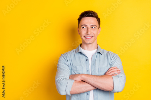 Portrait of attractive cheerful content guy folded arms copy blank space ad clue guess isolated over bright yellow color background © deagreez