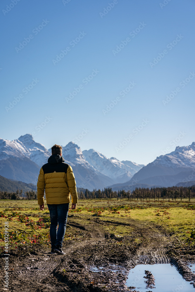 young man walking into rural area in Glenorchy, New Zealand