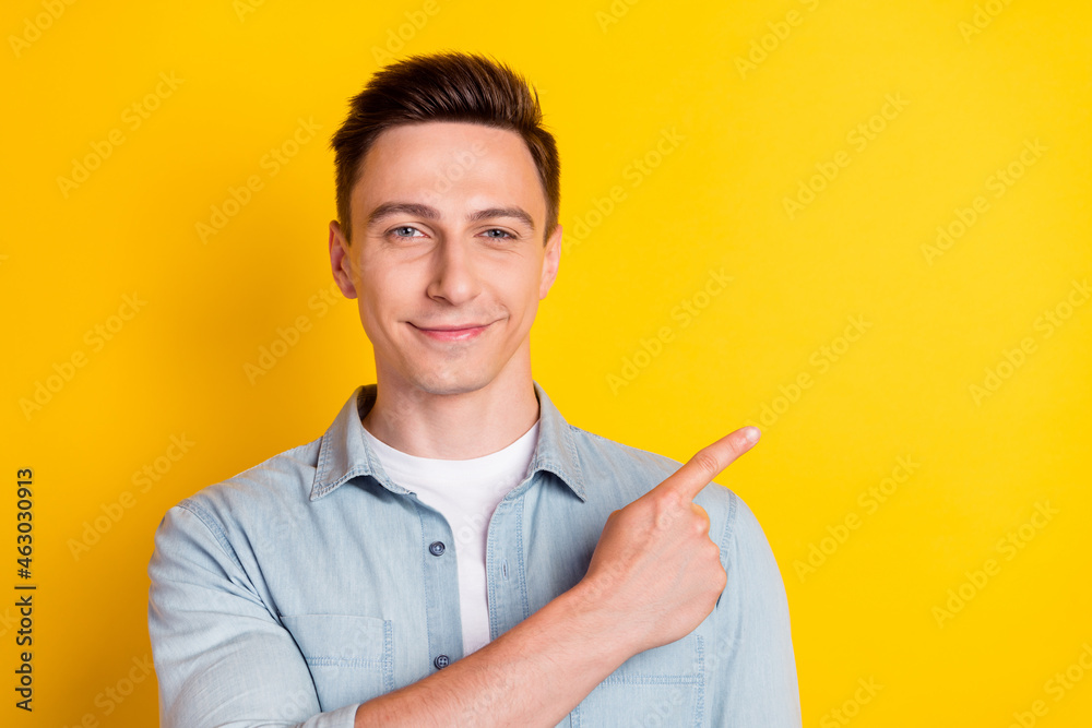 Portrait of young attractive smiling good mood man point finger copyspace recommend isolated on yellow color background Portrait of young attractive smiling good mood man point finger copyspace recommend isolated on yellow color background