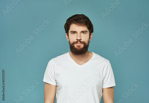 bearded man in a white t-shirt irritated facial expression close-up