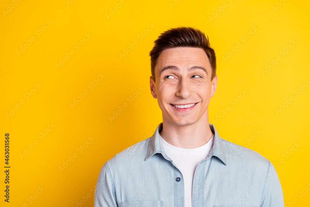 Photo of young cheerful toothy beaming guy look copyspace dreaming wear jeans shirt isolated on yellow color background Photo of young cheerful toothy beaming guy look copyspace dreaming wear jeans shirt isolated on yellow color background