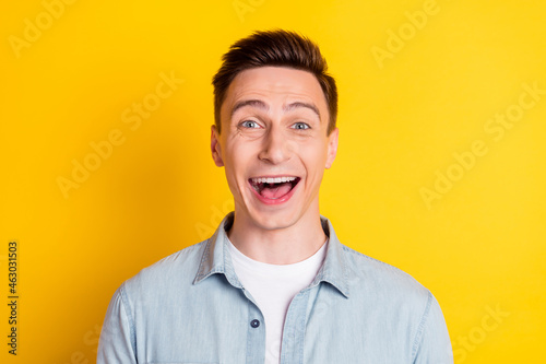 Portrait of attractive amazed cheerful guy having fun good mood isolated over bright yellow color background