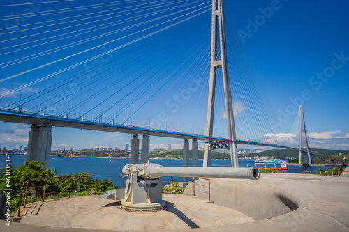 Gun of coastal batterie in Vladivostok fortress and Cable-stayed bridge. Island of Russian, Vladivostok, Russia