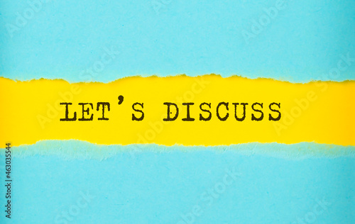 LET'S DISCUSS text on the torn paper , yellow background photo