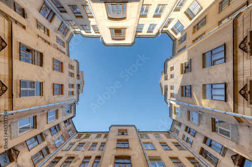 Photo of courtyard in old residential house from historical center of Saint Petersburg, Russia. Clear blue sky. The facade with many windows. Travel destination concept.