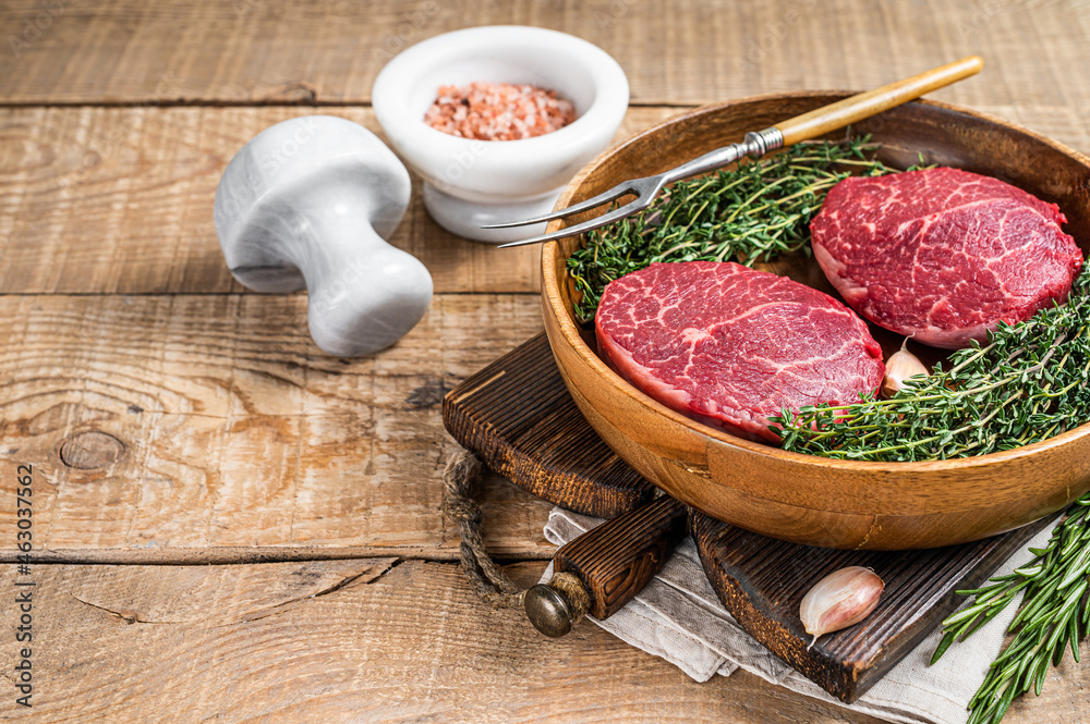 Fresh meat Fillet Mignon steaks from beef tenderloin. wooden background. Top view. Copy space