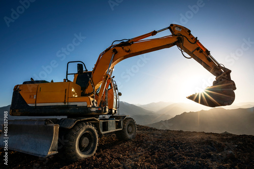 Billede på lærred Excavator is working on the hill at sunset