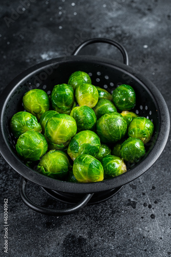 Brussels sprouts green cabbage in colander. Black background. Top view © Vladimir
