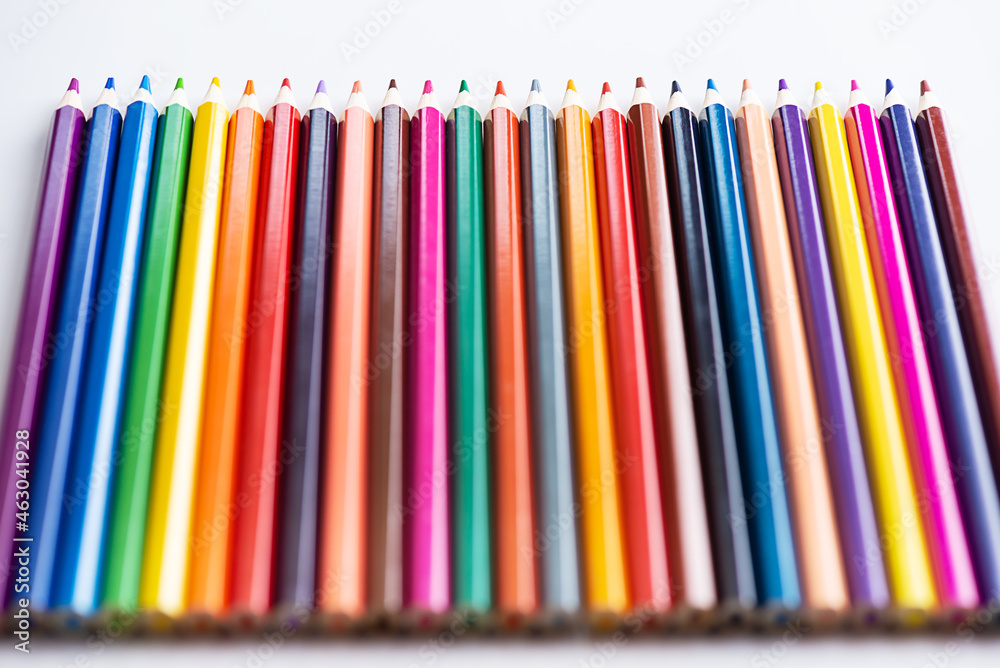 Multi-colored pencils in a row on a light background. Multi-colored pencils in a row on a light background.
