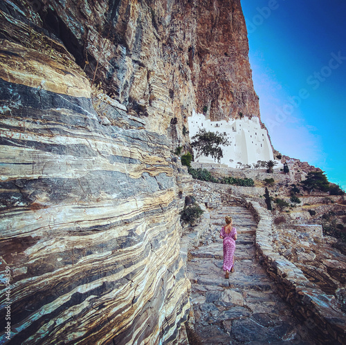 Woman following a stairs to visiting Orthodox monastry of Panagia Hozoviotissa on amorgos island, Greece, Cyclades
