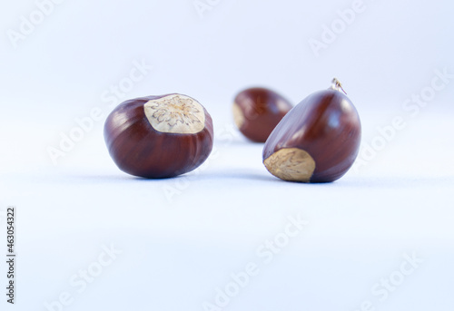 A group of three sweet chestnuts on a white background