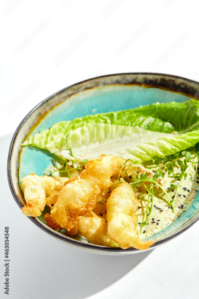 Delicious appetizers - tempura shrimp with peanut sauce. Japanese dish - crispy deep fried prawn. Tempura prawn with asian sauce isolated on white background. Hot deep fried seafood appetizer. Delicious appetizers - tempura shrimp with peanut sauce. Japanese dish - crispy deep fried prawn. Tempura prawn with asian sauce isolated on white background. Hot deep fried seafood appetizer.