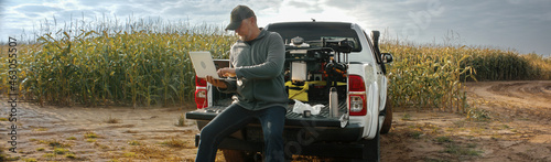 Photography 50s Caucasian male farmer checking his laptop while having a sandwich outside ea