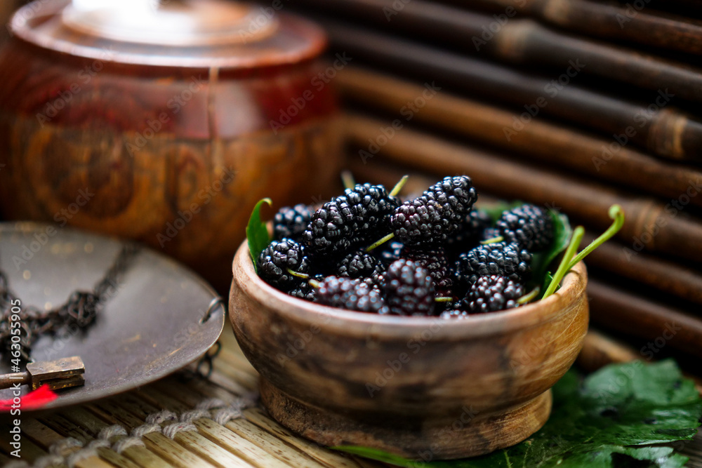 Ripe black mulberries in summer, freshly picked in wooden bowl Ripe black mulberries in summer, freshly picked in wooden bowl