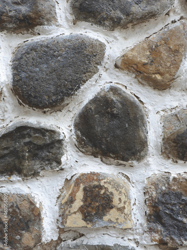 Round grey stones outside for backgrounds and backdrops. Textured rough ground. Vertical photo