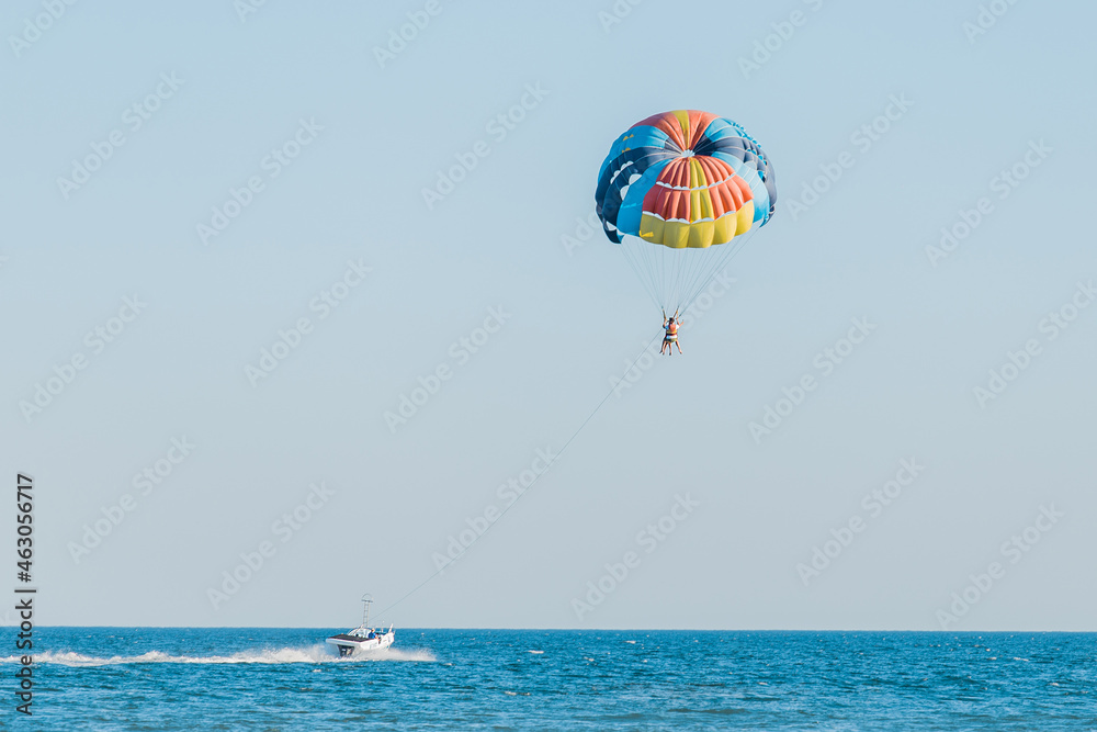 Ukraine, Iron Port - August 31, 2020: Extreme sports and exciting rest activity. Vacationing tourists fly on a parashute over the sea against the background of blue sky and horizon line Ukraine, Iron Port - August 31, 2020: Extreme sports and exciting rest activity. Vacationing tourists fly on a parashute over the sea against the background of blue sky and horizon line