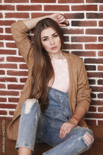 Young beautiful woman with long hair in jeans and cardigan © Iuliia