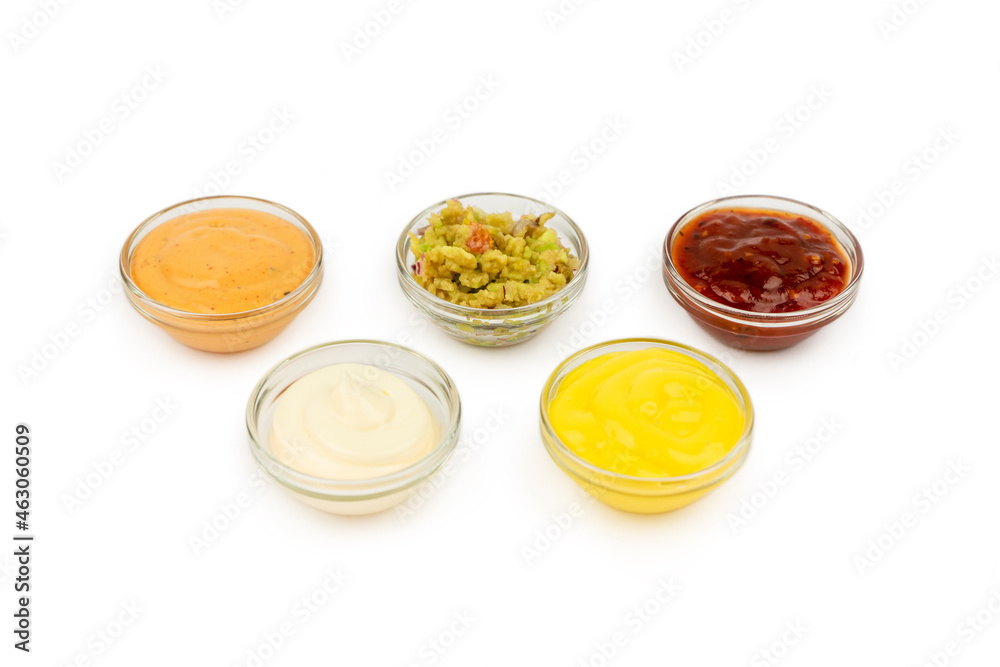 Bowls with Mexican cuisine sauces, guacamole, chili, cheese, paprika on a white plate. Bowls with Mexican cuisine sauces, guacamole, chili, cheese, paprika on a white plate.
