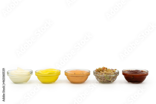 Bowls with Mexican cuisine sauces, guacamole, chili, raw, paprika on white background.