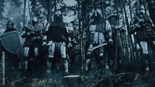 Epic Invading Army of Medieval Soldiers Standing in Forest Ambush. Armored Warriors with Swords, Getting Ready to Attack. War, Battle, Conquest. Historical Reenactment. photo