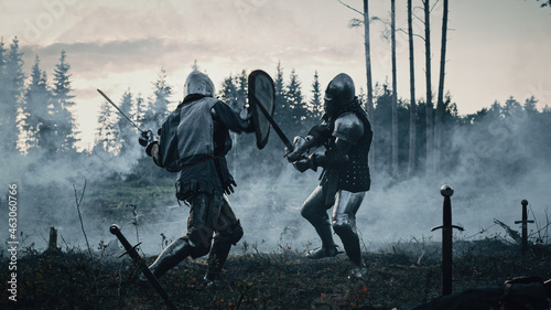 Epic Battlefield: Two Armored Medieval Knights Fighting with Swords. Dark Ages Army Warfare. Action Battle of Armed Warrior Soldiers, Killing Enemy. Cinematic Historical Reenactment.