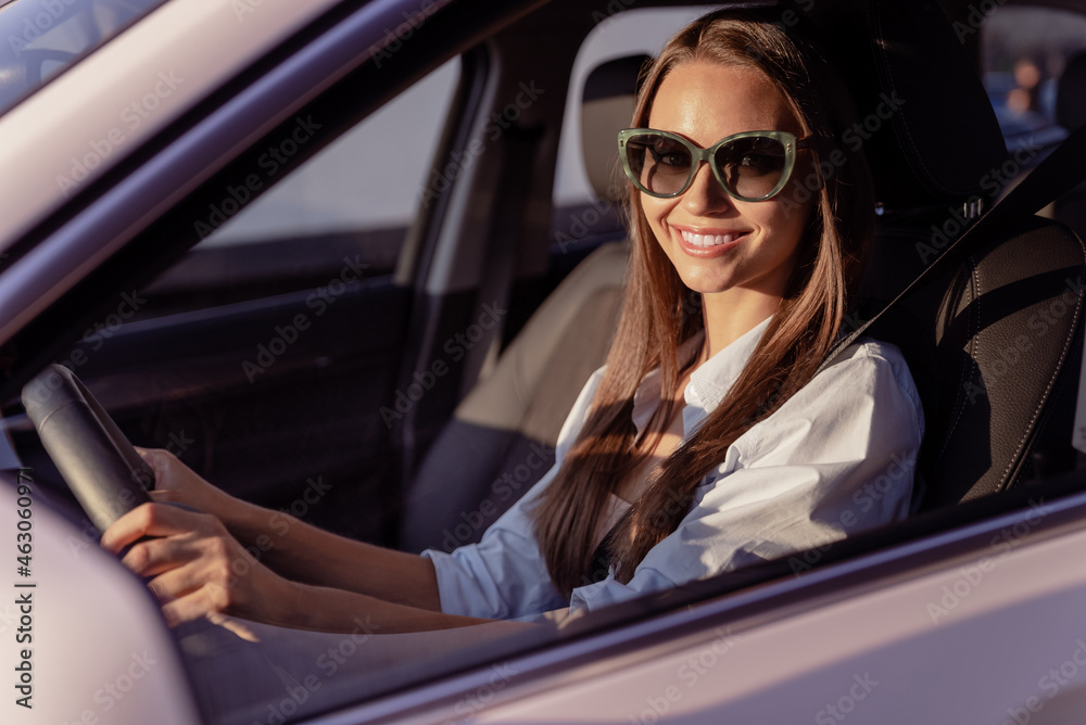 Photo of pretty adorable young woman wear white shirt dark glasses riding car smiling outside city street