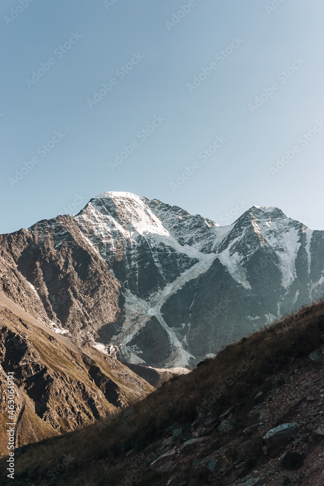 Snow-capped mountains of the caucasus close-up. On the Sunset. Vertical photo.