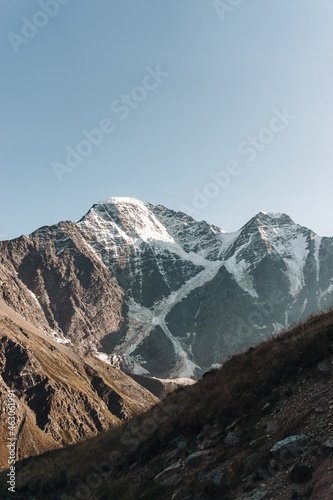 Snow-capped mountains of the caucasus close-up. On the Sunset. Vertical photo.